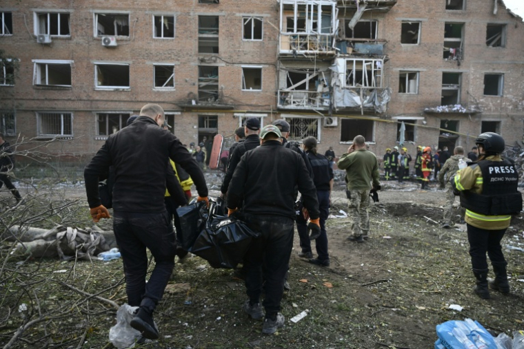 Des secouristes transportent un corps pendant des opérations de fouilles dans les décombres d'un immeuble touché par une frappe russe à Prylouky dans le Nord de l'Ukraine, le 7 octobre 2026 ( AFP / Genya Savilov )