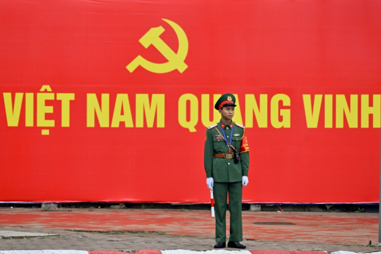 Un soldat devant une affiche annonçant le 14e Congrès du Parti communiste vietnamien, le 19 janvier 2026 à Hanoï ( AFP / Nhac NGUYEN )