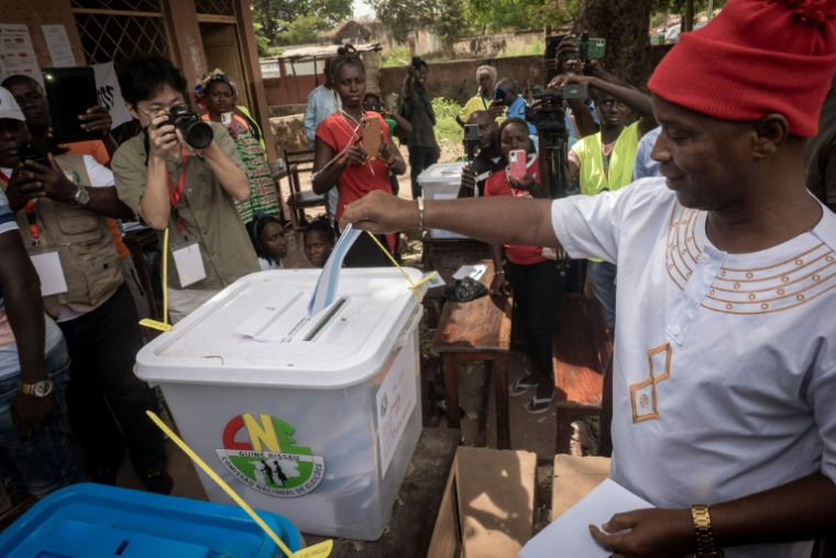 Le candidat à la présidentielle du Parti pour la rénovation sociale (PRS), Fernando Dias (à droite), vote dans un bureau de vote à Mansoa le 23 novembre 2025, lors des élections présidentielle et législatives en Guinée-Bissau. ( AFP / Samba BALDE )