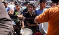 Des enfants palestiniens font la queue pour recevoir des repas d'une organisation caritative à Gaza-ville, le 14 juillet 2025 ( AFP / BASHAR TALEB )
