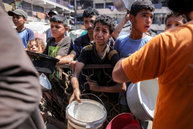 Des enfants palestiniens font la queue pour recevoir des repas d'une organisation caritative à Gaza-ville, le 14 juillet 2025 ( AFP / BASHAR TALEB )