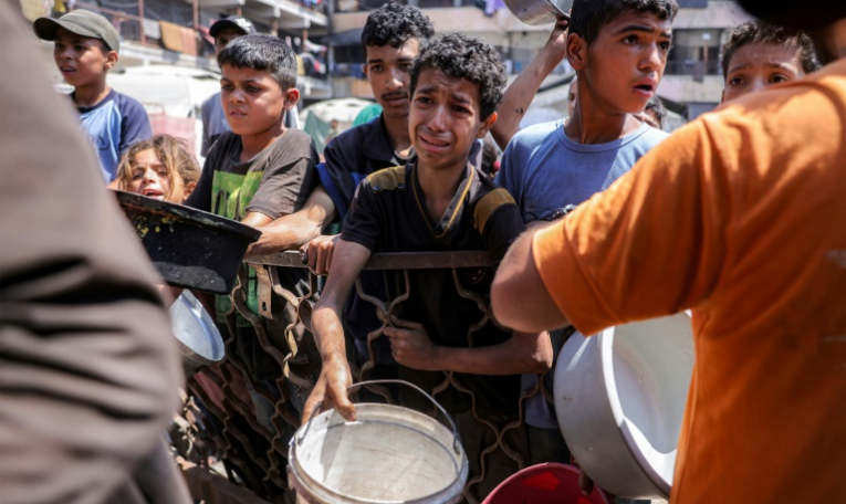 Des enfants palestiniens font la queue pour recevoir des repas d'une organisation caritative à Gaza-ville, le 14 juillet 2025 ( AFP / BASHAR TALEB )
