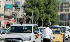 Un policier devant une file d'automobilistes qui attendent devant une station-service à Bagdad, le 5 septembre 2026 en Irak ( AFP / Murtaja LATEEF )