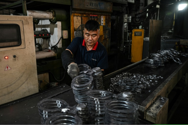 Un employé travaille sur une ligne de production de l'usine Wosen, un fabricant d'éclairages LED, le 17 avril 2025 à Zhongshan, dans la province du Guangdong, dans le sud de la Chine ( AFP / JADE GAO )