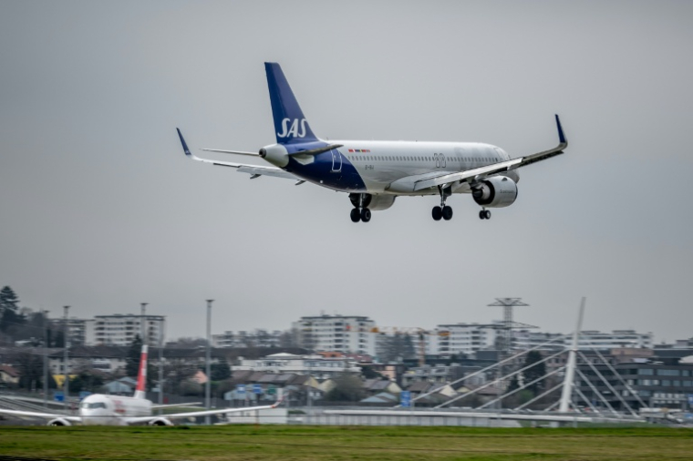 Un avion de la compagne aérienne scandinave SAS atterrit à l'aéroport de Genève, le 10 mars 2026 ( AFP / Fabrice COFFRINI )