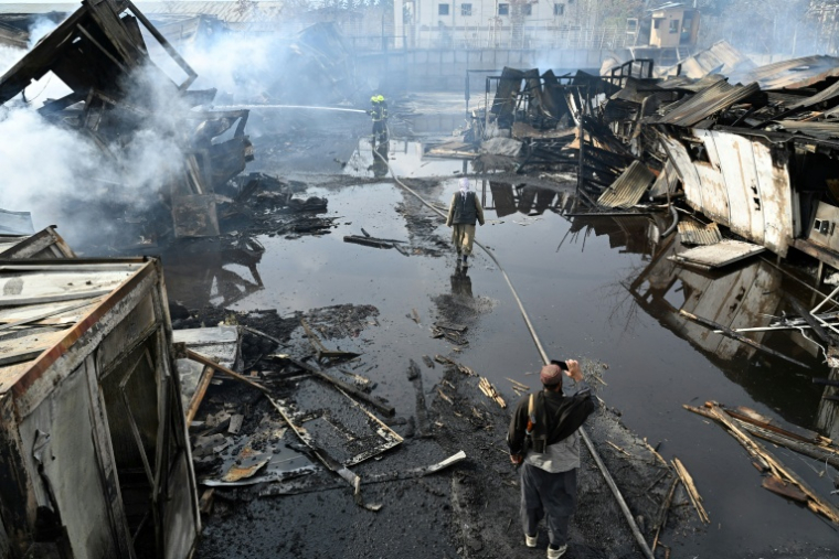 Des pompiers sur le site d'un hôpital pour toxicomanes touché par des frappes aériennes pakistanaises à Kaboul, le 17 mars 2026 en Afghanistan ( AFP / Wakil KOHSAR )