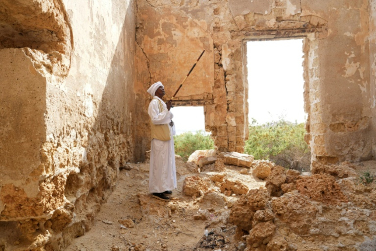 Un homme se tient debout dans une ruine à Suakin, au Soudan, le 22 janvier 2026  ( AFP / Mutawakil ISSA )