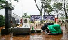 Sur cette photo prise le 7 octobre 2025, Ryh Jae-hong (2e à droite, vêtu de noir), fils d'un réfugié nord-coréen, se prosterne devant un autel sur l'île de Gyodong ( AFP / ANTHONY WALLACE )