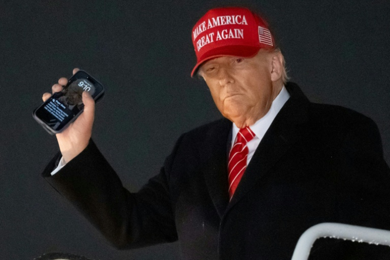 Le président américain Donald Trump, un smarthphone à la main, débarque d'Air Force à la base Andrews, dans le Maryland, de retour de Pennsylvanie où il a avoir visité une aciérie d'US Steel ( AFP / SAUL LOEB )