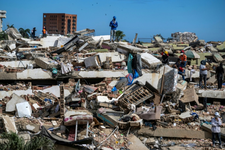 Des volontaires et des habitants cherchent des survivants du double séisme dans les ruines à Caraballe, dans l'Etat venezuelien de La Guaira, le 28 juin 2026 ( POOL / Miguel MEDINA )