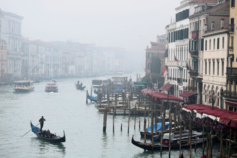 Un gondolier lors d'une journée brumeuse, à Venise