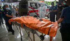 Le corps d'un étudiant tué dans l'effondrement d'un bâtiment à l'internat islamique Al Khoziny est transporté dans un sac mortuaire à l'hôpital Bhayangkara de Surabaya, dans la province de Java oriental, le 4 octobre 2025. ( AFP / Juni KRISWANTO )