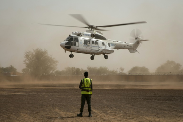 Un membre du Service aérien humanitaire des Nations unies (UNHAS) observe l'atterrissage d'un hélicoptère UNHAS à Dori, au Burkina Faso, le 31 mai 2024 ( AFP / FANNY NOARO-KABRÉ )