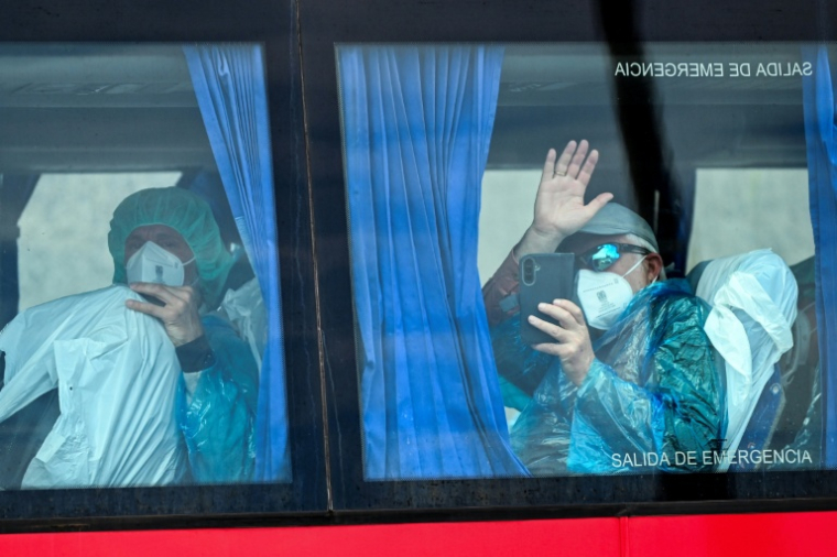 Des passagers du navire de croisière MV Hondius, touché par l'hantavirus, à bord d'un bus militaire, le 10 mai 2026 sur l'île espagnole de Tenerife ( AFP / JORGE GUERRERO )