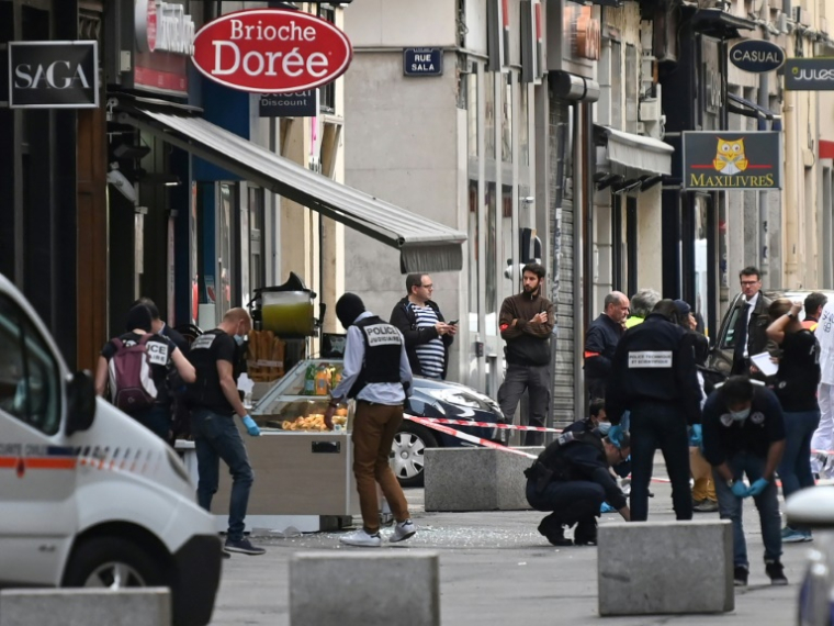 Des policiers cherchent des preuves après l'explosion d'une bombe dans le centre de Lyon le 24 mai 2019 ( AFP / PHILIPPE DESMAZES )
