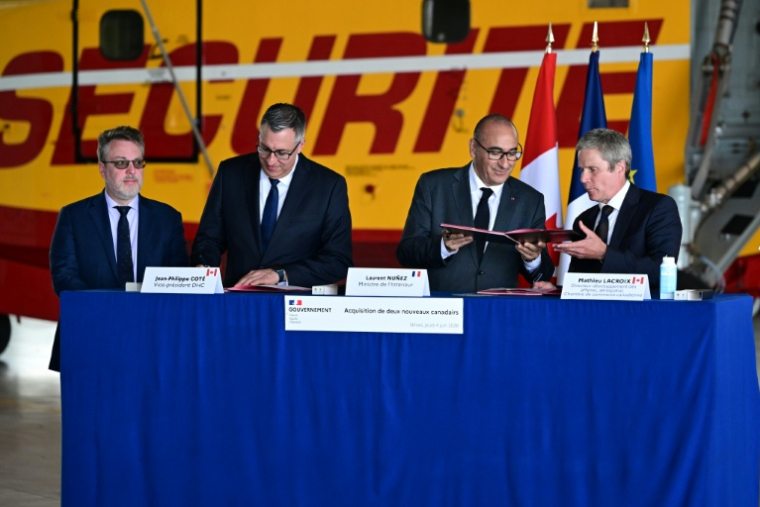 Le ministre de l'Intérieur Laurent Nuñez (2e d) lors de la signature d'un accord sur l'acquisition de deux avions De Haviland Canadair DHC-515, à la base aérienne de sécurité civile de Nîmes, le 4 juin 2026 dans le Gard ( AFP / Miguel MEDINA )