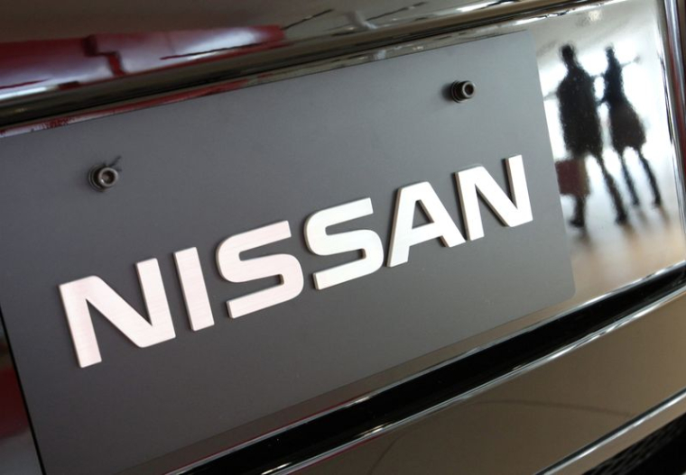 Des visiteurs se reflètent dans un véhicule de Nissan Motors au siège mondial de l'entreprise à Yokohama, au sud de Tokyo.