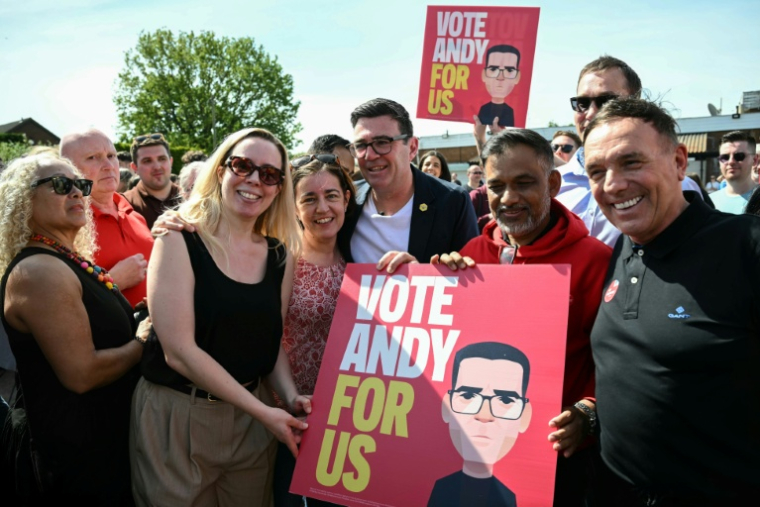 Le maire du Grand Manchester Andy Burnham (au centre) avec des partisans lors du lancement de sa campagne pour l’élection partielle à Ashton-in-Makerfield, le 22 mai 2026 ( AFP / Paul ELLIS )