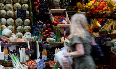 Une femme fait ses courses dans un magasin de fruits et légumes à Paris