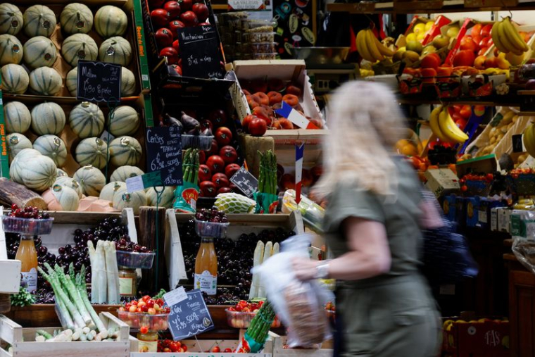 Une femme fait ses courses dans un magasin de fruits et légumes à Paris