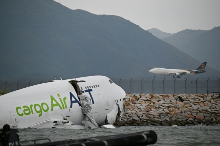 Un avion cargo Boeing dans l'eau après être sorti de piste lors de son atterrissage à l'aéroport international de Hong Kong, le 20 octobre 2025 ( AFP / Peter PARKS )