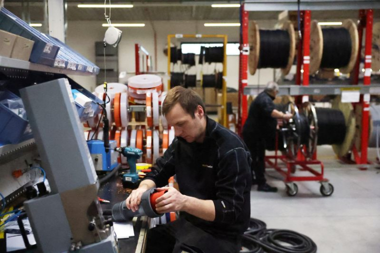 Des personnes travaillent sur des pièces de canons à neige à l'intérieur de l'usine TechnoAlpin, à Bolzano