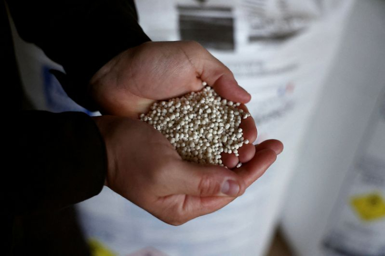 Guillaume Lefort, agriculteur français, tient des granulés d'engrais à Arville