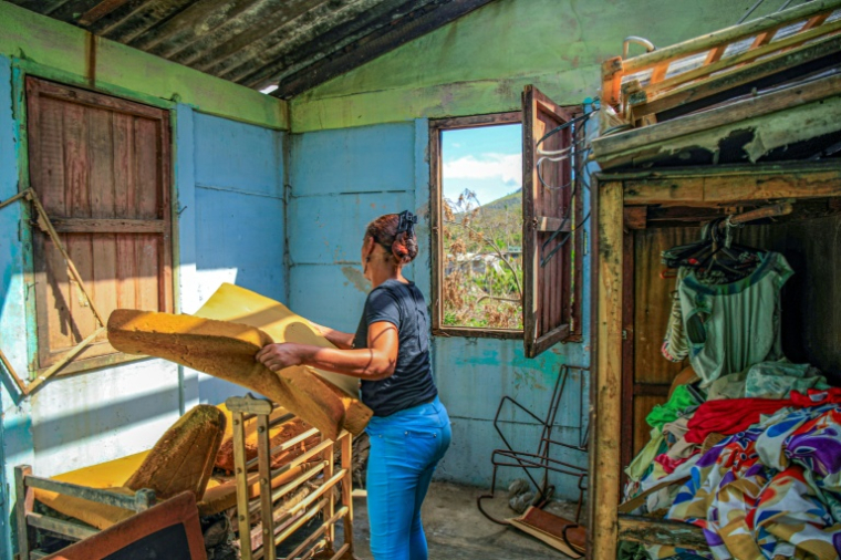 Une habitante fait sécher au soleil des matelas en mousse trois semaines après le passage de l'ouragan Melissa, à El Cobre, le 17 novembre 2025 à Cuba ( AFP / STRINGER )
