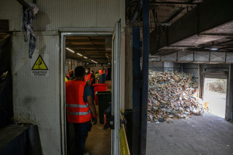 Des employés séparent le plastique des autres déchets dans une usine de recyclage à Corfou, en Grèce, le 15 octobre 2025 ( AFP / Angelos TZORTZINIS )