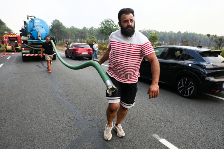 Des bénévoles viennent en aide aux pompiers près de Marcheprime, à une trentaine de kilomètres de Bordeaux, dans la lutte contre l'incendie qui sévit dans le sud-ouest de la France, le 26 juillet 2026 ( AFP / ROMAIN PERROCHEAU )