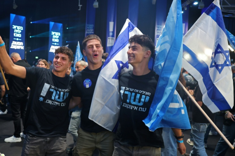 Des Israéliens saluent les premières estimations des résultats des législatives lors de la soirée électorale du parti Yashar de Gadi Eisenkot, le 27 octobre 2026 à Tel-Aviv ( AFP / Jack GUEZ )