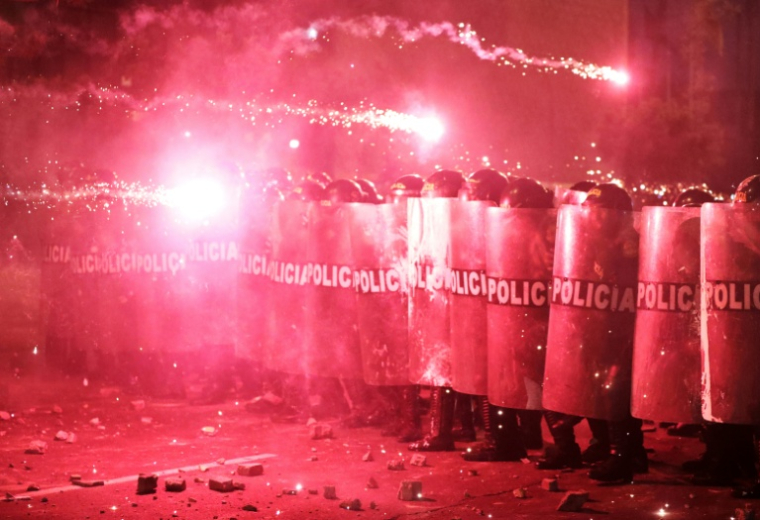 Des policiers antiémeutes se protègent des feux d'artifice alors qu'ils affrontent des manifestants lors d'une manifestation contre le président par intérim du Pérou, José Jeri, à Lima, le 15 octobre 2025 ( AFP / CONNIE FRANCE )