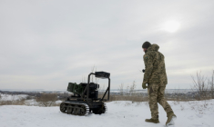 Un militaire ukrainien de la 30e brigade mécanisée indépendante prépare un véhicule terrestre robotisé sans pilote armé d'un lance-grenades Mk 19 pour un test dans un lieu non divulgué de la région de Donetsk le 27 janvier 2026. ( AFP / Tetiana DZHAFAROVA )