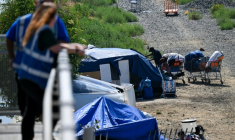 Des employés d'une association d'aide aux sans-abris veillent sur un campement de SDF, à Los Angeles, le 1er juin 2026 ( AFP / Patrick T. Fallon )