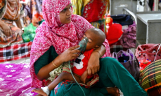 Une mère applique un nébuliseur sur le visage de son enfant soigné pour la rougeole dans un service de pédiatrie d'un hôpital de Dacca, le 9 avril 2026 au Bangladesh ( AFP / Munir UZ ZAMAN )