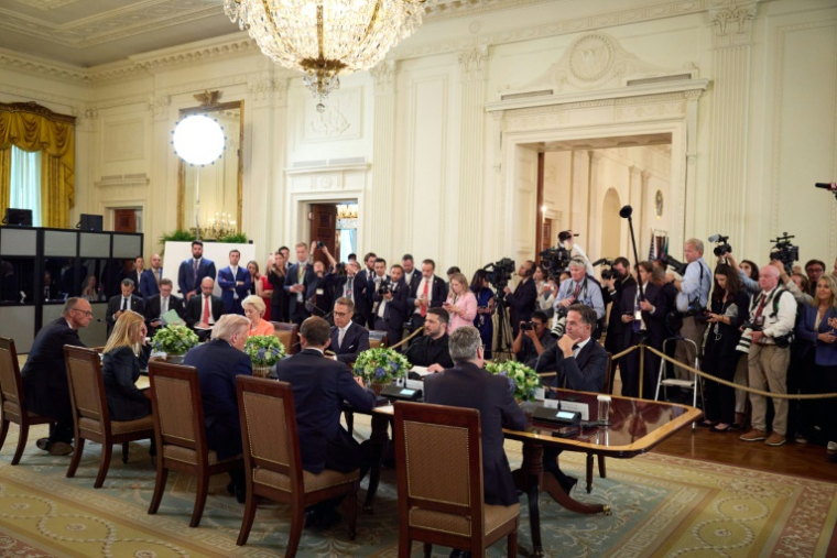 Le président ukrainien Volodymyr Zelensky (c) lors de sa rencontre avec le secrétaire général de l'Otan Mark Rutte, le Premier ministre britannique Keir Starmer, le président français Emmanuel Macron, le président américain Donald Trump, le président finlandais Alexander Stubb, la Première ministre italienne Giorgia Meloni, le chancelier allemand Friedrich Merz et la présidente de la Commission européenne Ursula von der Leyen à la Maison Blanche, le 18 août 2025 à Washington ( Service de presse de la présidence ukrainienne / Handout )