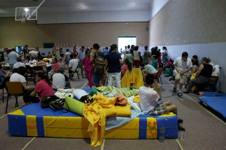 Des habitants évacués en raison d'un incendie de forêt près de San Martín de Valdeiglesias trouvent refuge dans une salle de sport à Villamanta, à l'ouest de Madrid, le 24 juillet 2026.  ( AFP / Pierre-Philippe MARCOU )