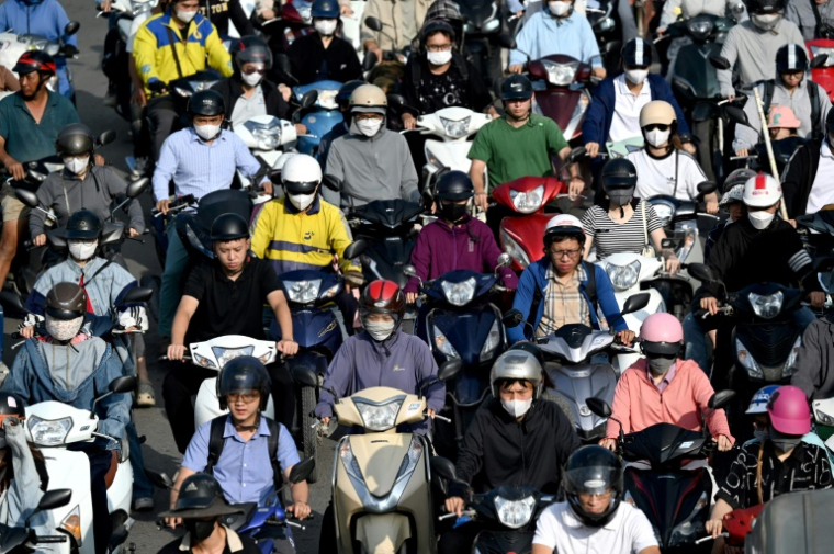Des conducteurs de deux-roues dans une rue de Hanoi, le 17 juillet 2025  ( AFP / Nhac NGUYEN )
