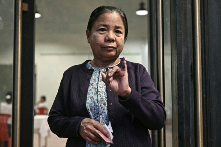 Une femme montre son doigt encré après avoir voté à Rangoun, le 28 décembre 2025 ( AFP / Lillian SUWANRUMPHA )