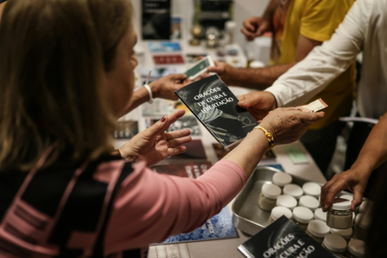 Des fidèles participant à une "retraite exorciste" achètent les livres du prêtre Francisco Marques à Fatima, le 30 mai 2026 au Portugal ( AFP / PATRICIA DE MELO MOREIRA )