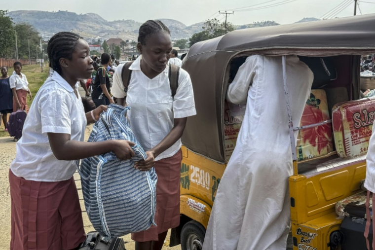 Des élèves chargent leurs bagages devant une école publique de filles à Bwari, dans les faubourgs d'Abuja, le 22 novembre 2025, fermée par les autorités après plusieurs enlèvements de masse dans des établissements scolaires ( AFP / John OKUNYOMIH )