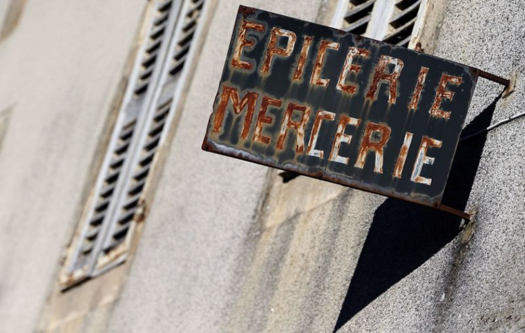 Un panneau rouillé d'une épicerie à Sousceyrac