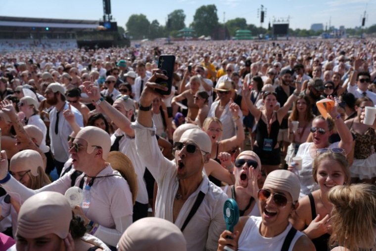 Des fans du rappeur américain Pitbull portent de faux crânes chauves avant un concert de l'artiste, le 10 juillet 2026 à Londres  ( AFP / CARLOS JASSO )