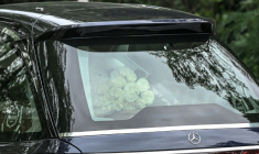 Quelques badauds venus assister au passage du corbillard attendaient derrière des barrières de sécurité, certains avec des roses blanches, à l'instar de celles posées sur le cercueil du créateur de mode mondialement célèbre. ( AFP / Piero CRUCIATTI )