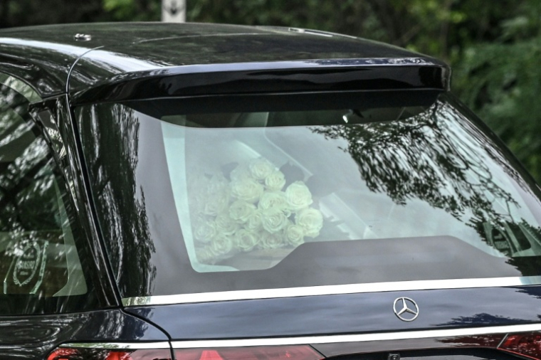 Des roses blanches osées sur le cercueil du défunt créateur de mode italien Giorgio Armani alors que le corbillard arrive pour ses funérailles à l'église San Martino de Rivalta, près de Plaisance, dans le nord de l'Italie, le 8 septembre 2025 ( AFP / Piero CRUCIATTI )