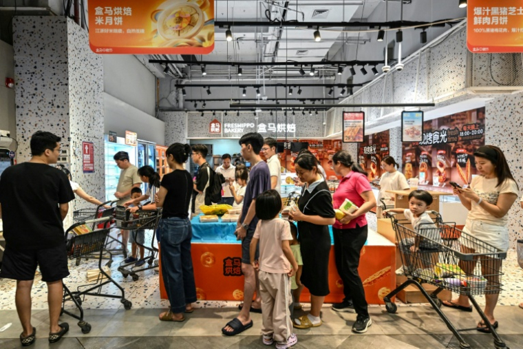 Des habitants de Shenzhen, ville du sud de la Chine voisine de Hong Kong, font des provisions dans un supermarché à l'approche du typhon Ragasa, le 22 septembre 2025 ( AFP / Adek BERRY )