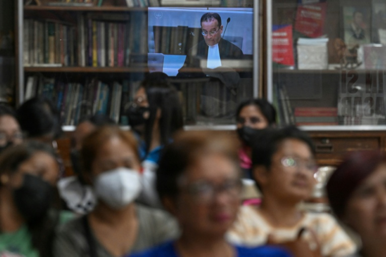 Des proches de victimes de la guerre contre la drogue de l'ancien président philippin Rodrigo Duterte regardent, depuis Quezon City, dans la métropole de Manille, la retransmission de l'audience à La Haye, le 26 février 2026 ( AFP / Jam STA ROSA )