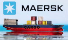 Un modèle de porte-conteneurs devant le logo Maersk