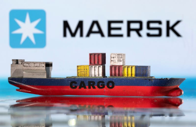 Un modèle de porte-conteneurs devant le logo Maersk