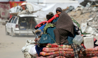 Des Palestiniens transportant quelques biens fuient la villede Gaza, le 16 mai 2025 ( AFP / Bashar TALEB )
